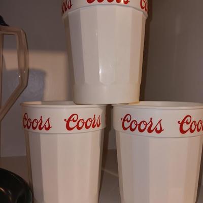 Plastic pitcher with six plastic Coors cups and green plastic plates