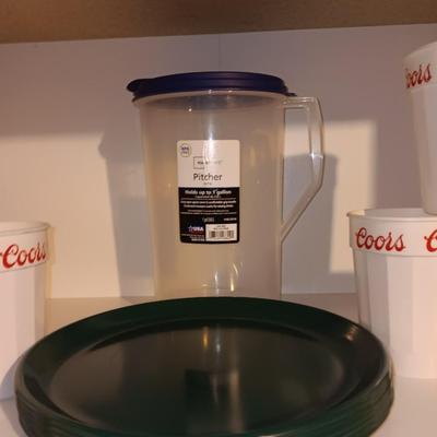 Plastic pitcher with six plastic Coors cups and green plastic plates