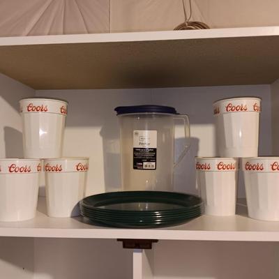 Plastic pitcher with six plastic Coors cups and green plastic plates