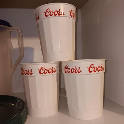 Plastic pitcher with six plastic Coors cups and green plastic plates