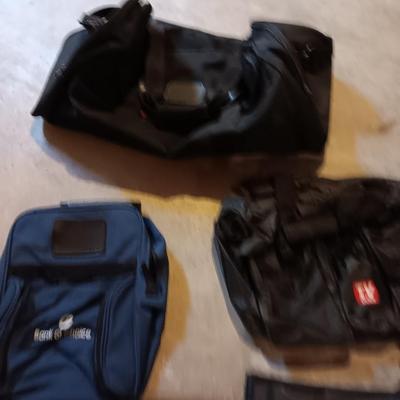 Several black bags - Duffles backpacks - suit covers