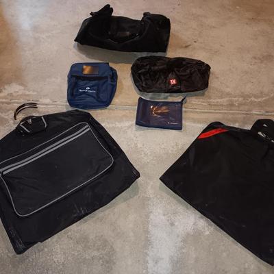 Several black bags - Duffles backpacks - suit covers