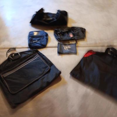 Several black bags - Duffles backpacks - suit covers