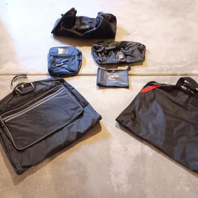 Several black bags - Duffles backpacks - suit covers