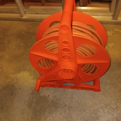 5' wooden ladder with an orange extension cord on a reel
