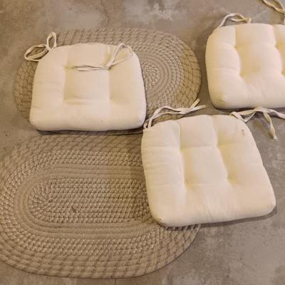 Two woven throw rugs and three white seat / chair cushions