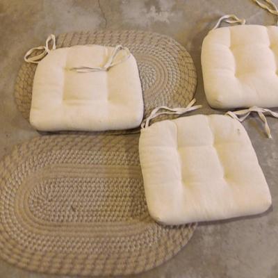 Two woven throw rugs and three white seat / chair cushions