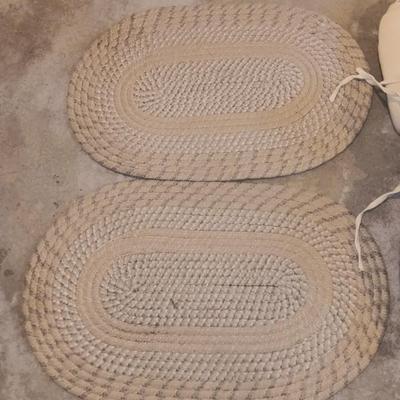 Two woven throw rugs and three white seat / chair cushions