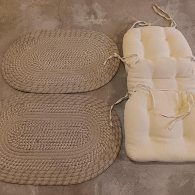 Two woven throw rugs and three white seat / chair cushions