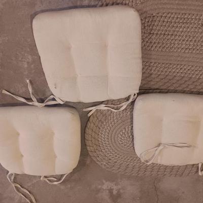 Two woven throw rugs and three white seat / chair cushions