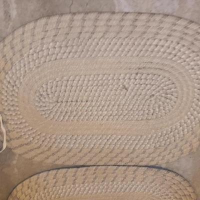 Two woven throw rugs and three white seat / chair cushions