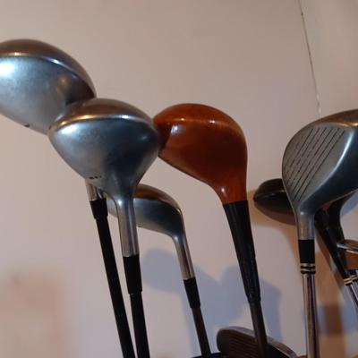 Golf bags with golf clubs and accessories.