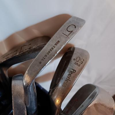 Golf bags with golf clubs and accessories.