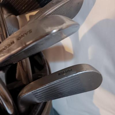 Golf bags with golf clubs and accessories.