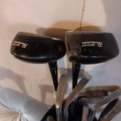 Golf bags with golf clubs and accessories.