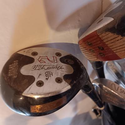 Golf bags with golf clubs and accessories.