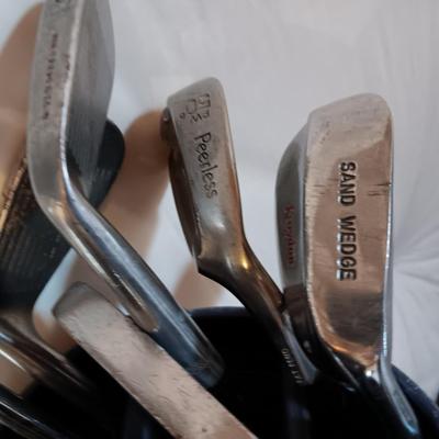 Golf bags with golf clubs and accessories.