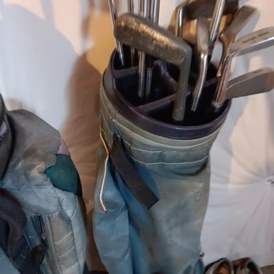 Golf bags with golf clubs and accessories.