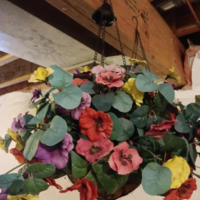 Three metal hanging baskets with faux flowers