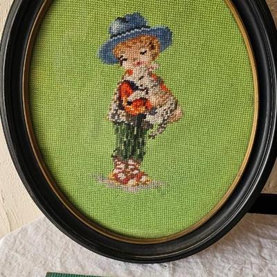 Pair of oval needlepoint framed pictures of children playing with puppies!
