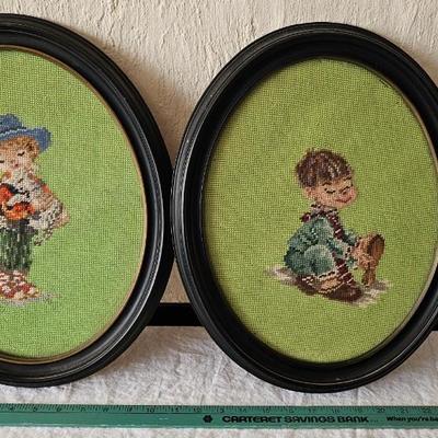 Pair of oval needlepoint framed pictures of children playing with puppies!