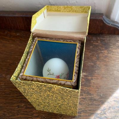 Vintage hand painted Chinese egg in a glass display case