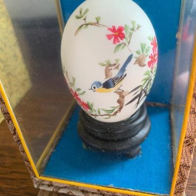 Vintage hand painted Chinese egg in a glass display case