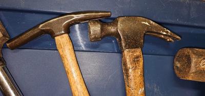 3 hammers with wood handles and one hatchet