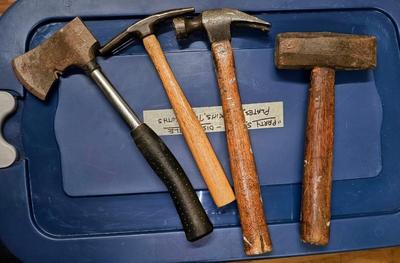 3 hammers with wood handles and one hatchet