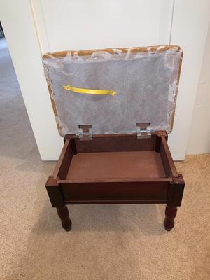 small upholstered footstool with hinged top