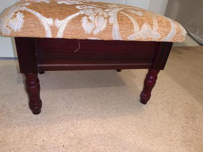 small upholstered footstool with hinged top