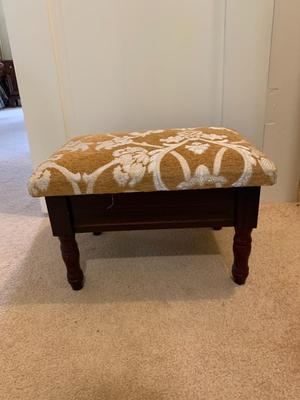 small upholstered footstool with hinged top