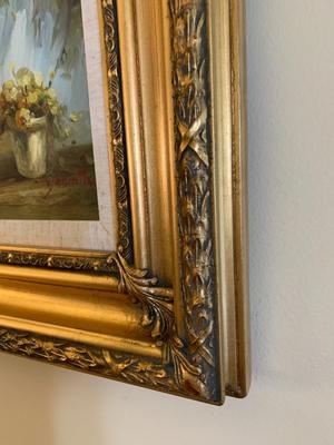 Gold framed oil painting with accent light