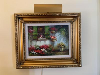 Gold framed oil painting with accent light