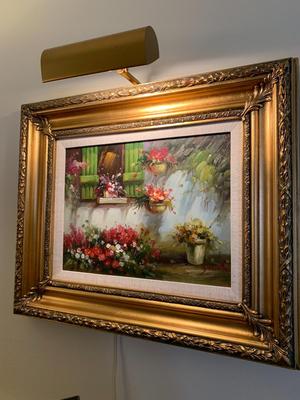 Gold framed oil painting with accent light