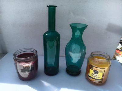 Colored bottle and vase with two scented candles in jars