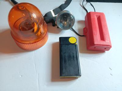 Orange security warning flasher / siren light with vintage metal battery operated head lamp and flashlight.