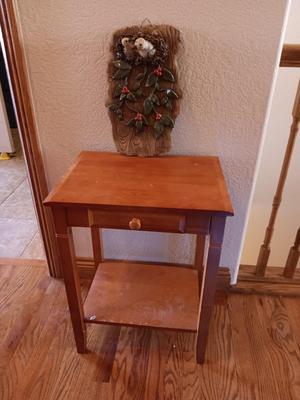 Small wooden accent table with drawer and unique pottery birds in a nest artwork