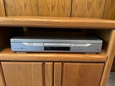 WOODEN CABINET ON CASTERS AND A SHARP DVD PLAYER W/REMOTE