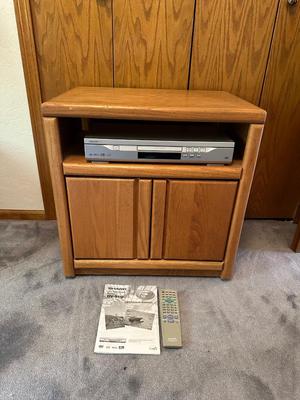 WOODEN CABINET ON CASTERS AND A SHARP DVD PLAYER W/REMOTE