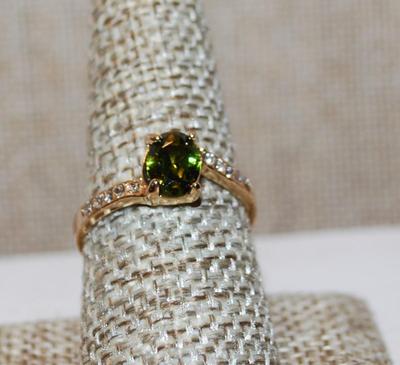 Size 9 Oval Peridot Colored Stone Ring with Side Accents on a Gold Tone Band (2.1g)