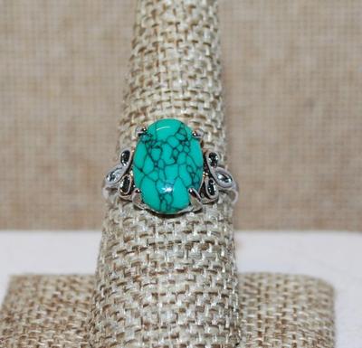 Size 8 Crackled Oval Turquoise Stone Ring with 3 Pelal Lily as Side Accents on a Silver Tone Band (3.2g)
