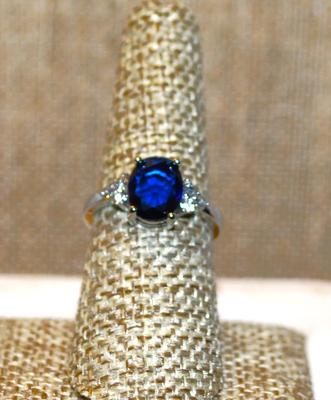 Size 8 Deep Blue Oval Center Stone Ring with 3 Clear Stones Side Accents on a Silver Tone Band (2.9g)