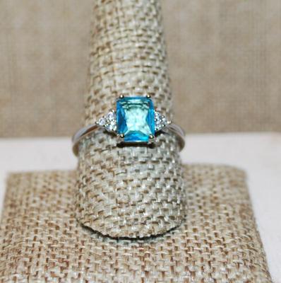 Size 10 Rectangle Shaped Transparent Blue Stone Ring with 3 Stone Side Accents on a Silver Tone Band (3.0g)