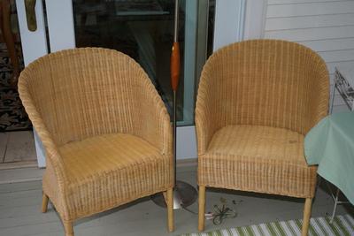 PAIR OF WICKER SIDE CHAIRS NATURAL COLOR THAT ALSO COMES WITH FLORAL SLIP COVERS AND CUSHION