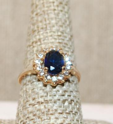 Size 8 Deep Blue Oval Cut Stone Ring with a Full Surround of Clear Stones on a Gold Tone Band (2.8g)