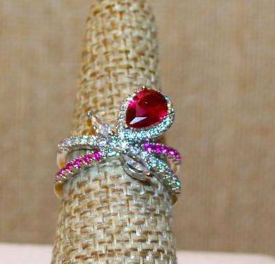 Size 7 Pretty Bowtie Style Ring with a Red Pear Cut Main Stone and Pink/Clear "Ribbons" on a Silver Tone Band (4.4g)
