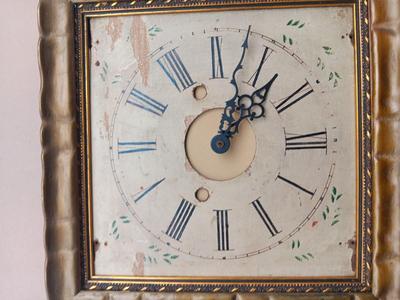 Wooden face clock framed in an art deco gold frame