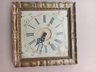 Wooden face clock framed in an art deco gold frame