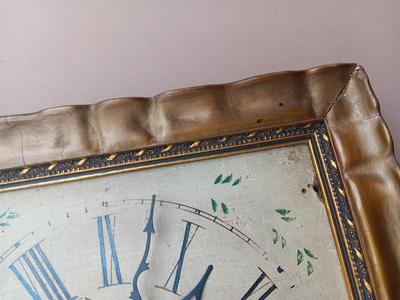 Wooden face clock framed in an art deco gold frame